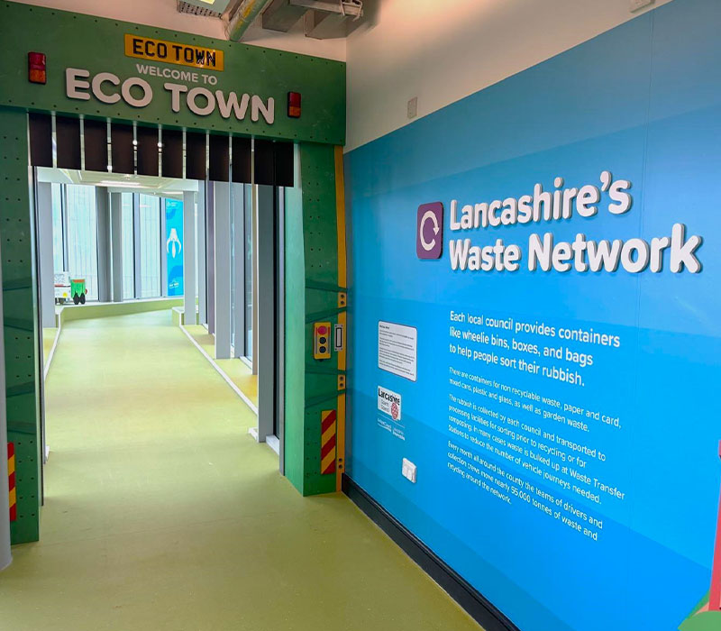 Branded doorway design at the front entrance of Eco Town, along with a large format wall graphic.