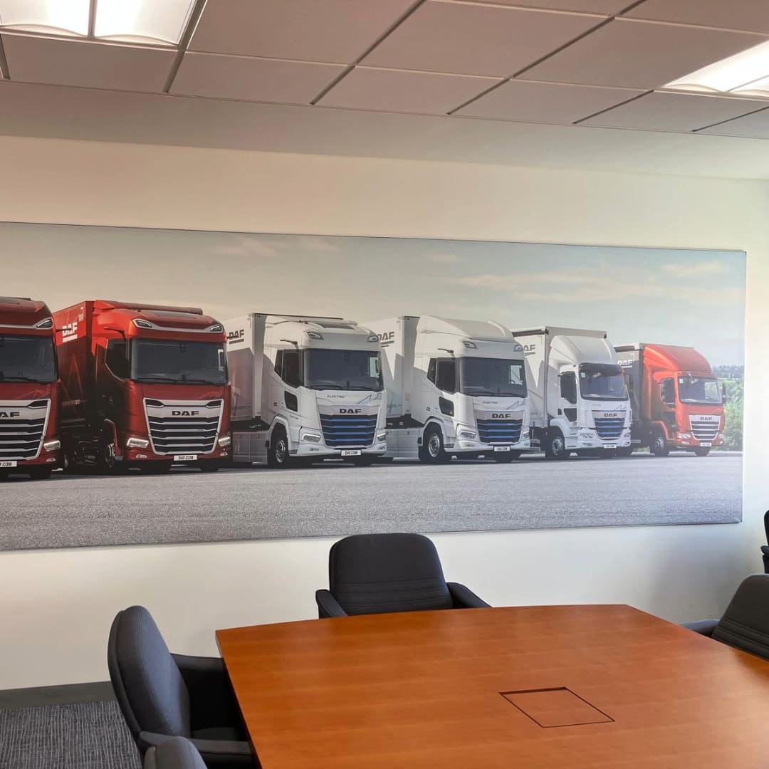 Large format graphic featuring a dozen DAF trucks, in a boardroom of one of DAF Trucks UK offices 
