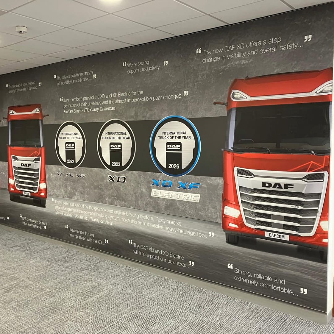 Large format wallpaper with two images of red DAF trucks, along with DAF Trucks testimonials and awards 